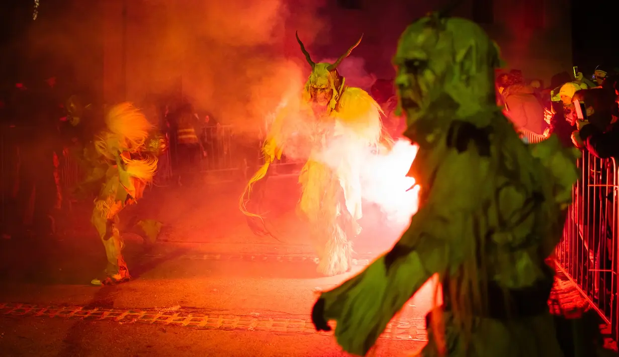 Partisipan berpakaian seperti Krampus, makhluk setengah iblis, saat ambil bagian dalam parade di kota Podkoren, Slovenia, Jumat (30/11). Parade bagian dari tradisi natal itu menghadirkan sosok Krampus untuk menakuti anak-anak yang nakal (Jure Makovec/AFP)