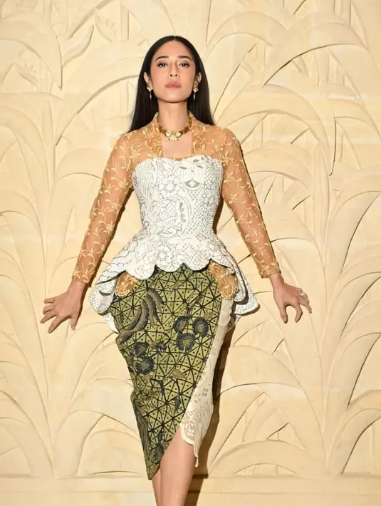 Dian Sastrowardoyo tampil apik dengan kebaya modern lengan coklat semi transparan berbordir dengan aksen bustier warna putih kehijauan dipadukan bawahan kain batik. Serta aksesori gold kalung dan anting-antingnya. [@therealdisastr]