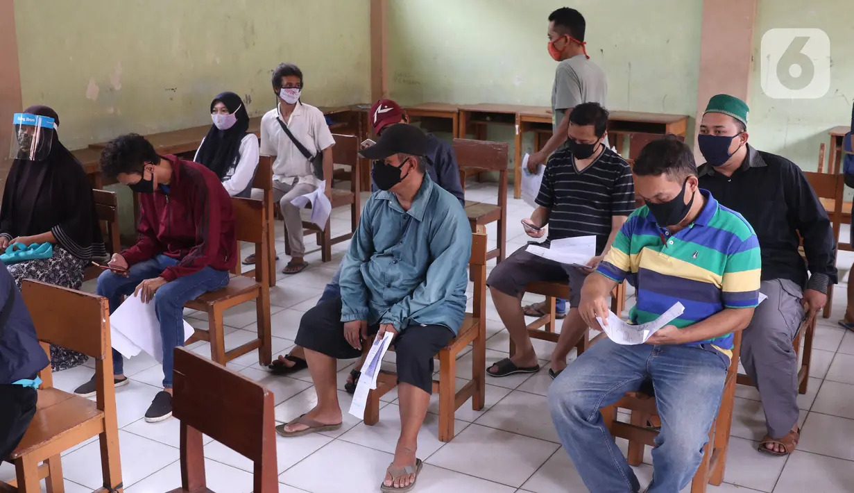 Warga mengantre untuk mendapatkan bantuan sosial (bansos) yang diberikan Pemerintah Provinsi Banten di Pinang, Tangerang, Jumat (1/5/2020). Bansos berupa uang tunai sebesar Rp 600 ribu tersebut diberikan kepada warga yang terdampak virus corona COVID-19. (Liputan6.com/Angga Yuniar)