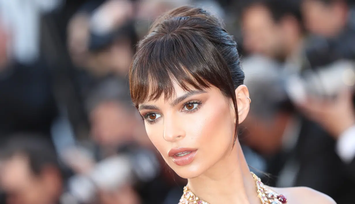 Ekspresi Emily Ratajkowski saat menghadiri pembukaan Festival Film Cannes ke-70 di Cannes, Prancis (17/5). Mengenakan gaun berwarna kream  Emily Ratajkowski saat melintas di karpet merah. (AFP Photo/Valery Hache)