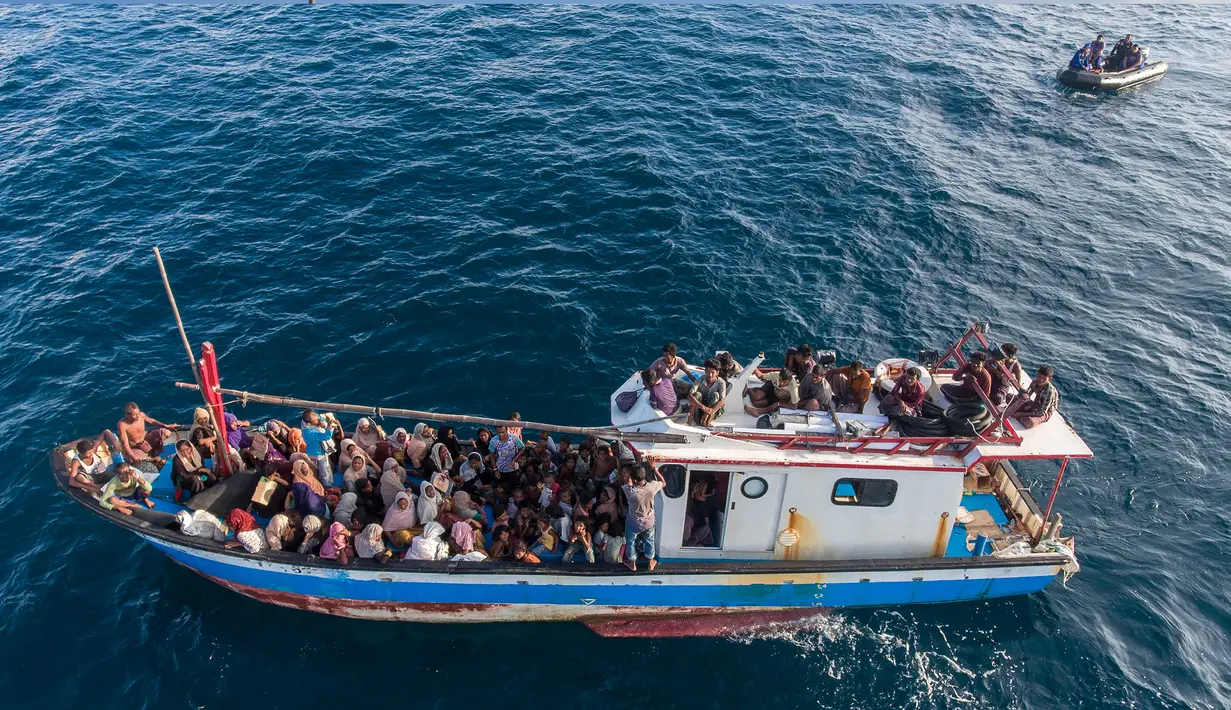 Pengungsi etnis Rohingya berada di atas kapal milik nelayan Indonesia di pesisir Pantai Seunuddon, Aceh Utara (24/6/2020).  Para pengungsi Rohingya diselamatkan nelayan Aceh setelah kapal yang ditumpangi puluhan pengungsi itu rusak. (AP Photo/Zik Maulana)