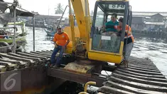 Menteri Koordinator Bidang Kemaritiman Luhut Binsar Panjaitan menaiki traktor menggelar gerakan aksi bersih di kawasan pesisir Cilincing, Jakarta Utara, Sabtu (6/4). Acara itu dalam rangka memperingati Hari Bumi. (Liputan6.com/Immanuel Antonius)