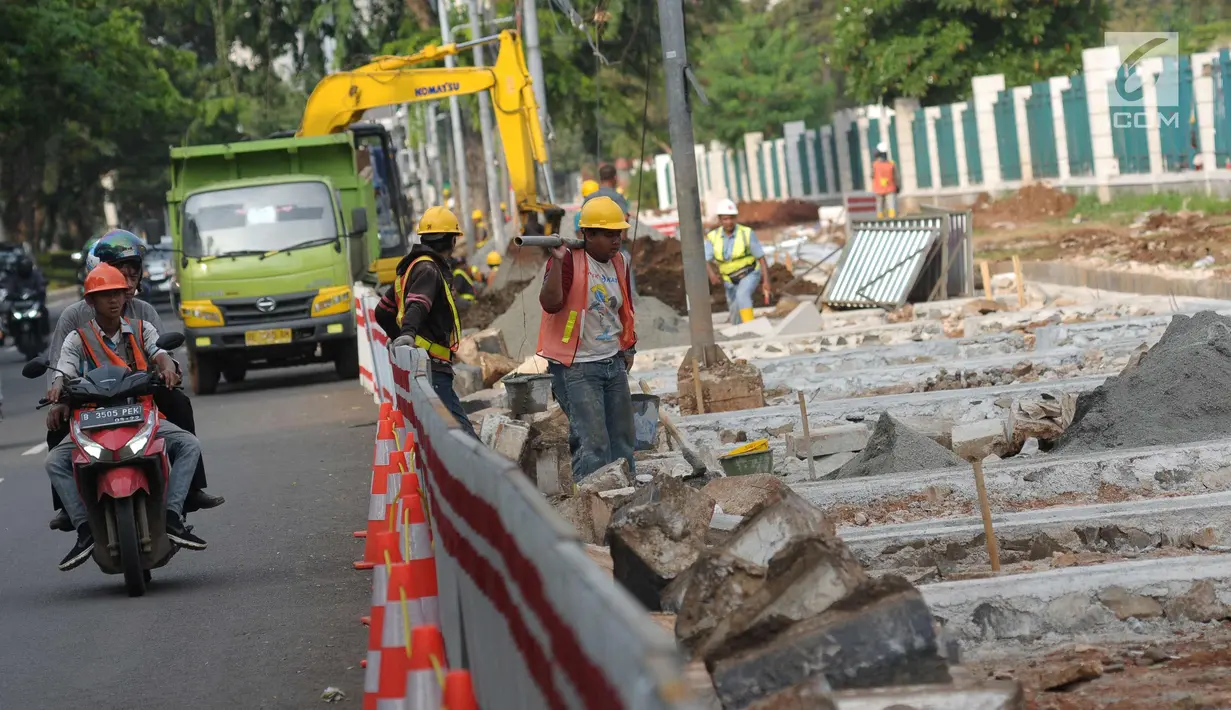 Pekerja melakukan pengerjaan renovasi pedestrian di kawasan Jalan Gerbang Pemuda, Jakarta, Selasa (17/4). Jelang perhelatan Asian Games XVIII, pedestrian di sekitar kawasan Gelora Bung Karno (GBK) terus ditata. (Liputan6.com/Helmi Fithriansyah)