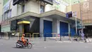 Pengendara sepeda motor melintas di samping Gedung Blok B Pasar Tanah Abang, Jakarta, Minggu (17/6). Pasar Tanah Abang tutup sejak 15 Juni 2018 dan buka kembali pada 25 Juni 2018. (Liputan6.com/Arya Manggala)