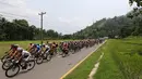 Para pebalap sepeda berlomba dalam Etape 1 Tour de Singkarak antara Painan, Kabupaten Pesisir Selatan menuju Pariaman, Sumatra Barat, Sabtu (3/10/2015). (Bola.com/Arief Bagus)