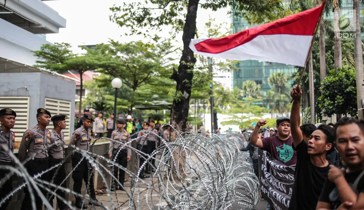 Aparat kepolisian mengawal aksi pengemudi online individu yang tergabung dalam GERHANA (Gerakan HAntam aplikasi Nakal) di kantor pusat Grab, Jakarta, Senin (29/10). Dalam aksinya ini mereka mengusung sejumlah tuntutan. (Liputan6.com/Faizal Fanani)