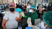 Seorang warga negara asing (WNA) menerima vaksin virus corona COVID-19 AstraZeneca di klinik vaksinasi massal darurat di Denpasar, Bali, Selasa (6/7/2021). Indonesia tengah memerangi gelombang infeksi baru yang belum pernah terjadi sebelumnya. (SONNY TUMBELAKA