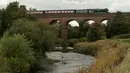 Lokomotif uap Flying Scotsman berjalan di sepanjang jalur East Lancashire Railway di Roch Valley Viaduct, Inggris, 5 September 2018. Flying Scotsman merupakan sebuah lokomotif uap yang diproduksi tahun 1923 di Doncester, South Yorkshire. (OLI SCARFF/AFP)