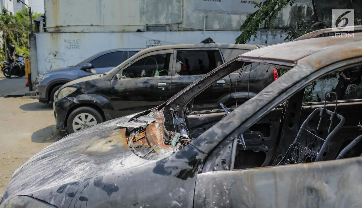 Kondisi mobil yang dibakar dan dirusak massa pasca bentrok pengunjuk rasa dan polisi di Polsek Tanah Abang, Jakarta, Selasa (1/10/2019). Mobil yang sedang terparkir tersebut diduga telah dibakar oleh para demonstran sekitar pukul 22.00 WIB. (Liputan6.com/Faizal Fanani)