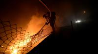 Petugas berusaha memadamkan api dalam kebakaran hutan di kawasan Galicia di Spanyol utara dan Portugal selatan (AFP)