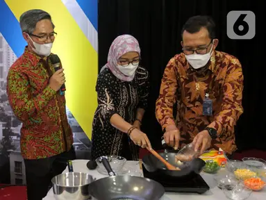 Dirut Bank BTN Haru Koesmahargyo (kanan) memasak menggunakan kompor induksi dalam acara Ayo Investasi Properti di Kawasan Transit Oriented Development (TOD) dan Launching KPR/KPA Platinum Bundling Kompor Induksi Bersama Bank BTN di Jakarta, Rabu (28/4/2021). (Liputan6.com/Pool/BTN)