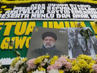 Karangan bunga dengan foto Presiden Iran Ebrahim Raisi terlihat diletakkan di depan Kedutaan Besar (Kedubes) Iran untuk Indonesia di Jakarta, Selasa (21/5/2024). (Liputan6.com/Herman Zakharia)