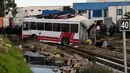 Sebuah kereta menghantam bus yang melintas di rel dekat wilayah Sidi Fathallah, sekitar 10 km selatan Ibu Kota Tunisia, Rabu (28/12). Bus itu terbelah dua ketika dihantam kereta dan menyebabkan lima orang tewas serta 34 lainnya terluka. (Fethi Belaid/AFP)