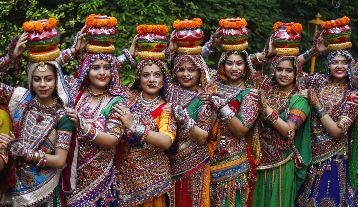 Para wanita mengenakan pakaian tradisional sebelum berlatih tarian tradisional negara bagian Gujarat, Garba, jelang Festival Navratri di Ahmadabad, India, Jumat (1/10/2021). Festival Navratri yang berlangsung sembilan malam pada musim gugur akan dimulai dari 7 Oktober. (AP Photo/Ajit Solanki)