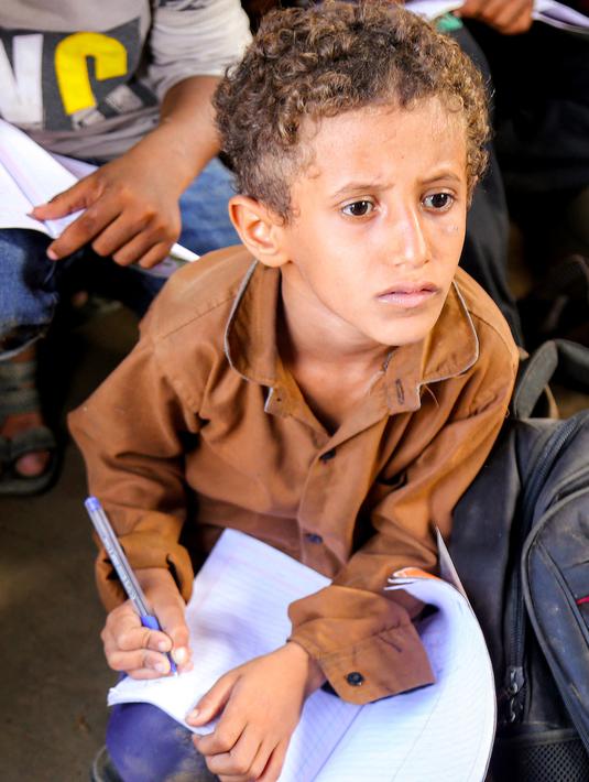 Meski aktivitas belajar mengajar dilakukan di luar gedung, anak-anak di Yaman tetap terlihat antusias. (Khaled ZIAD/AFP)