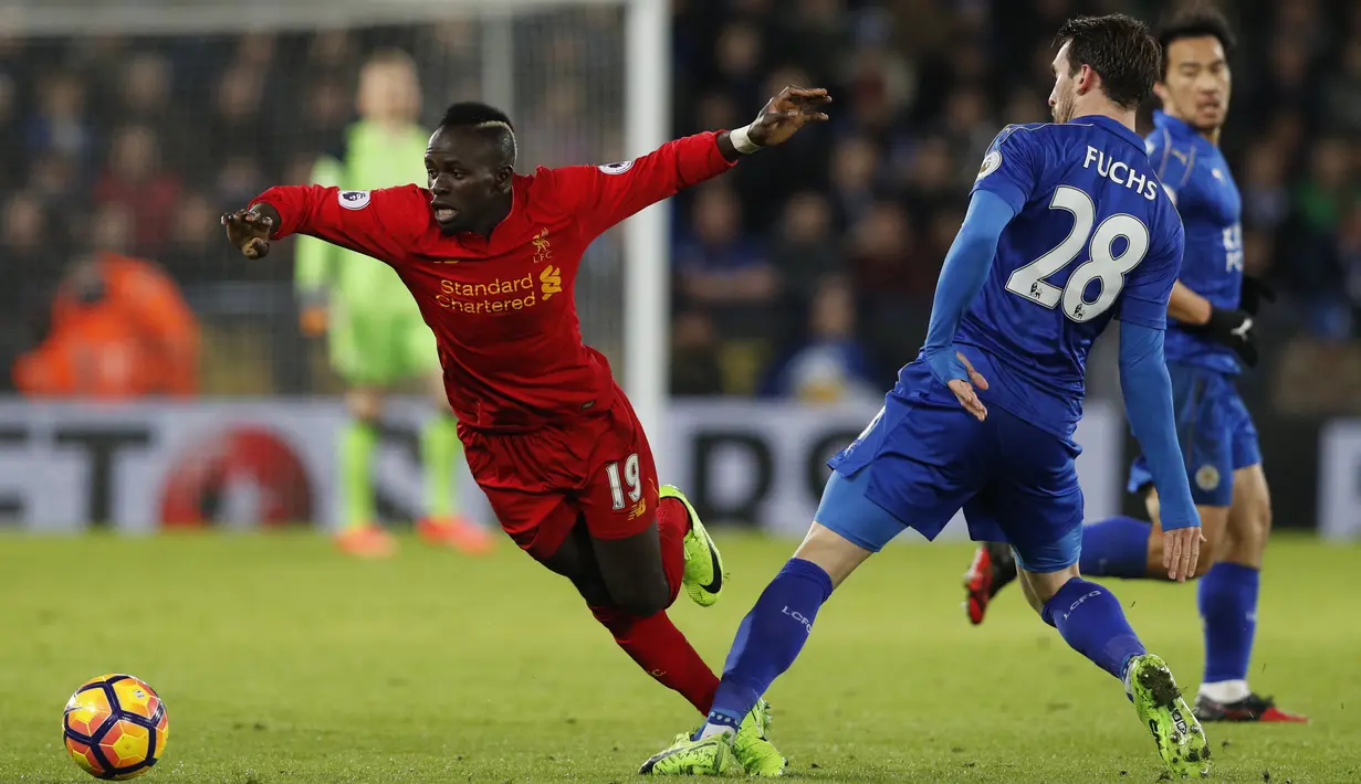 Gelandang Liverpool, Sadio Mane berusaha melewati bek Leicester City, Christian Fuchs pada lanjutan Liga Inggris di stadion King Power, (28/2). Leicester City menang atas Liverpool dengan skor 3-1. (AFP Photo / Adrian Dennis)