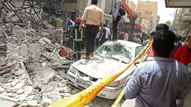 Mobil tergencet beton bangunan 10 lantai yang roboh di barat daya Kota Abadan, Iran pada 23 Mei 2022 - TASNIM NEWS/AFP