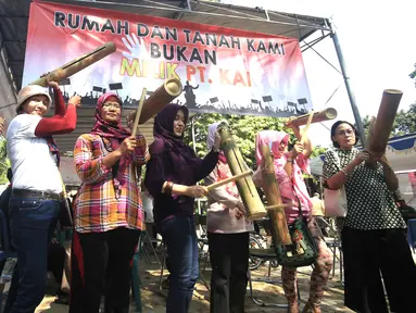 Puluhan warga melakukan aksi '1000 Kentongan Melawan Pengosongan Paksa' di Manggarai, Jakarta, Minggu (30/7). Mereka memprotes rencana pengosongan rumah yang dilakukan PT KAI terhadap rumah negara yang dihuni pensiunan. (Liputan6.com/Angga Yuniar)