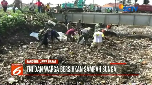 Pengerukan sampah juga dilakukan secara manual oleh anggota TNI dan relawan yang masuk ke dalam sungai.