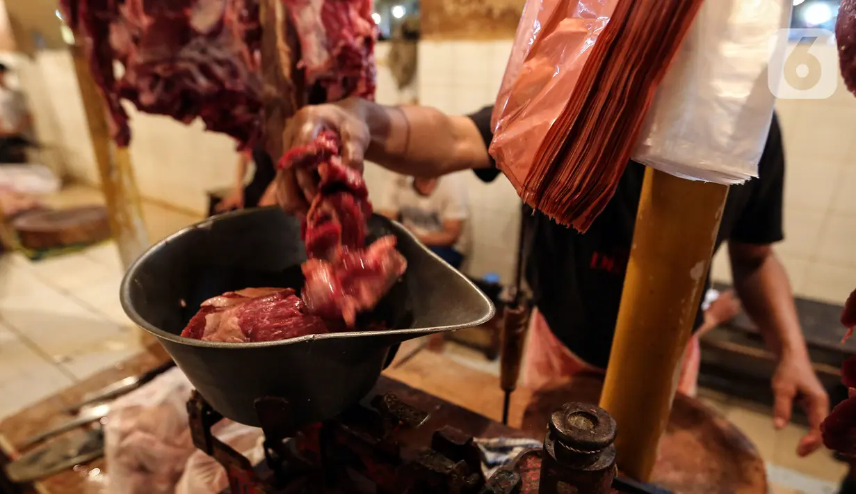 Pedagang menimbang daging potong di Pasar Kebayoran Lama, Jakarta, Kamis (24/2/2022). Pedagang daging mengeluhkan harga yang terus naik dan merencanakan mogok dagang mulai hari Senin, 28 Februari 2022 mendatang jika harga daging tidak turun. (Liputan6.com/Johan Tallo)