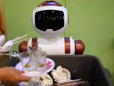 Robot mengumpulkan piring-piring tamu yang telah kotor di Chilli Padi Nonya Cafe, Singapura, (6/7). Restoran atau hotel di Singapura kekurangan tenaga kerja, Kebanyakan dari mereka memilih untuk menggunakan robot untuk bekerja. (REUTERS / Edgar Su)