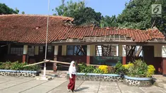 Seorang siswa melintasi bangunan kelas yang ambruk di SD Negeri Kotabatu 08 Kecamatan Ciomas Kabupaten Bogor, Senin (23/7). Ambruknya salah satu bangunan kelas mengakibatkan terganggunya proses kegiatan belajar mengajar. (Merdeka.com/Arie Basuki)