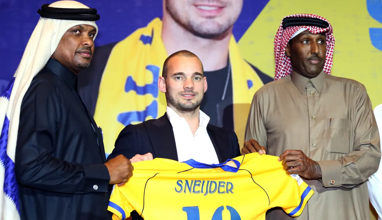 Pemain internasional Belanda, Wesley Sneijder memegang jersey nomor 10 saat diperkenalkan sebagai pemain baru klub Qatar, Al Gharafa, di Doha, Senin (8/1). Mantan gelandang Inter Milan dan Real Madrid itu dikontrak selama 18 bulan ke depan. (STRINGER/AFP)