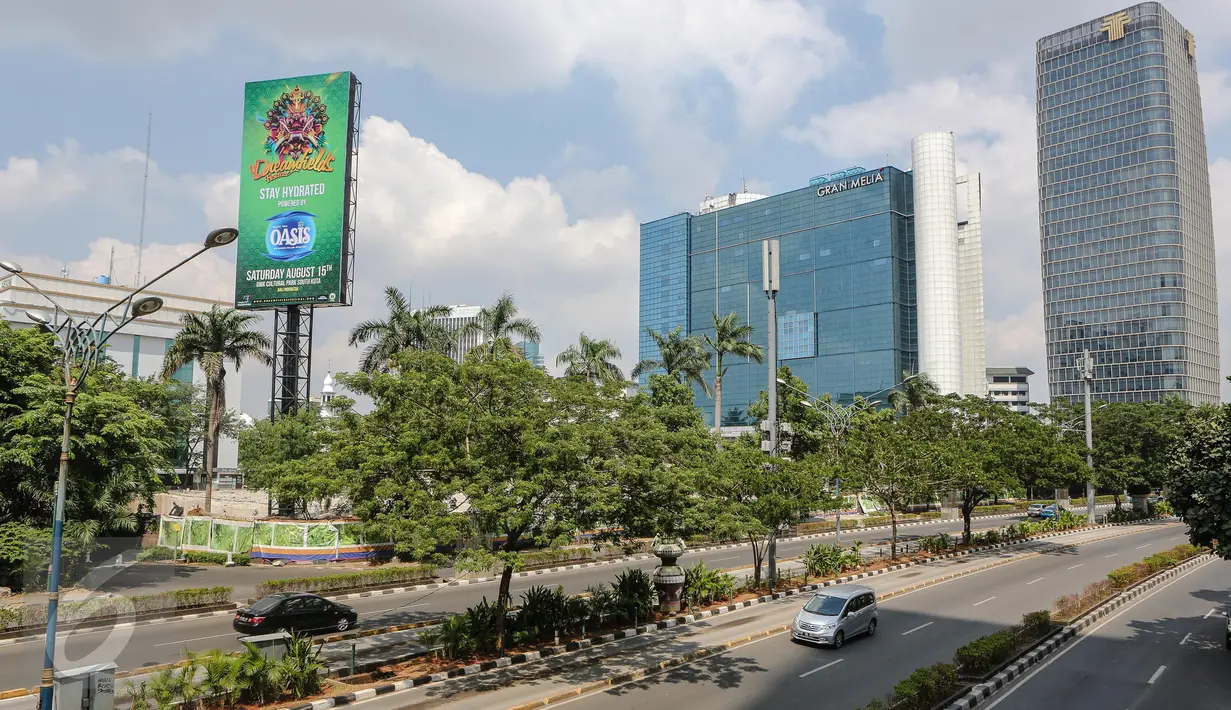 Sebuah mobil melewati jalan protokol yang lengang di kawasan Kuningan, Jakarta, Kamis (16/7/2015). H-1 jelang Lebaran, situasi Ibukota Jakarta sudah sepi ditinggal warganya yang mudik ke kampung halaman. (Liputan6.com/Faizal Fanani)
