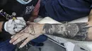 Naim Abdallah saat membuat desain tato pada tangan klien di ruang kerjanya di Kota Betlehem, Tepi Barat (24/1/2021). Naim Abdallah merupakan seorang penata rambut dan seniman tato Palestina di Kota Betlehem, Tepi Barat. (AFP/Hazem Bader)