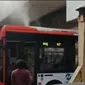 Beredar sebuah video yang memperlihatkan bus Transjakarta, Metrotrans tersangkut dan mengeluarkan asap dari bagian atas bu (Istimewa)