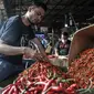 Pedagang merapikan cabai rawit merah di Pasar Induk Kramat Jati, Jakarta Timur, Rabu (14/12/2022). Telur ayam ras terpantau naik menjadi Rp 31.250 per kg, bawang merah menjadi Rp 38.200 per kg, cabai rawit merah menjadi Rp 54.600 per kg, cabai rawit hijau menjadi Rp 46.500 per kg, dan minyak goreng curah Rp 15.000 per kg. (merdeka.com/Iqbal S. Nugroho)