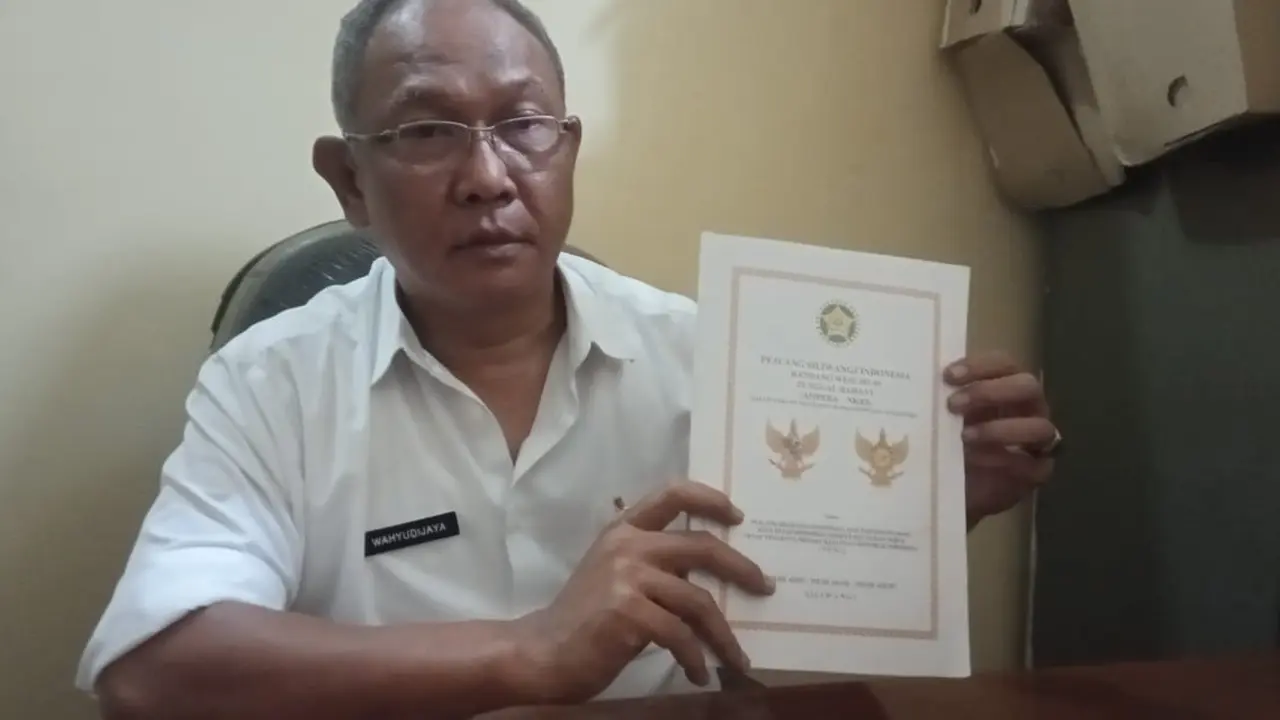 Kepala Kesbangpol Garut, Wahyudijaya menunjukan perubahan posisi Kepala Burung Garuda pada lambang negara Garuda Pancasila.