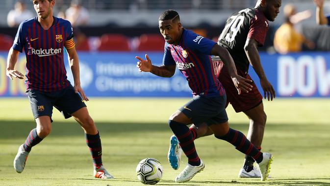 Penyerang Barcelona Malcom Silva menggiring bola melewati gelandang AC Milan Franck Kessie saat bertanding pada ICC 2018 di Levi's Stadium di Santa Clara, California (4/8). Milan menang tipis 1-0 atas Barcelona. (AFP Photo/Lachlan Cunningham)