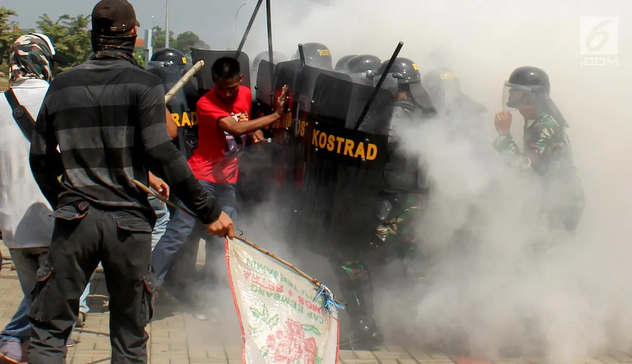 Petugas gabungan berlindung saat bentrok dengan pengunjuk rasa dalam simulasi pengamanan Pemilu 2019 di ICE BSD, Tangsel, Banten, Jumat (8/2). Kegiatan ini untuk mengantisipasi gangguan keamanan selama pelaksanaan Pemilu 2019. (Merdeka.com/Arie Basuki)