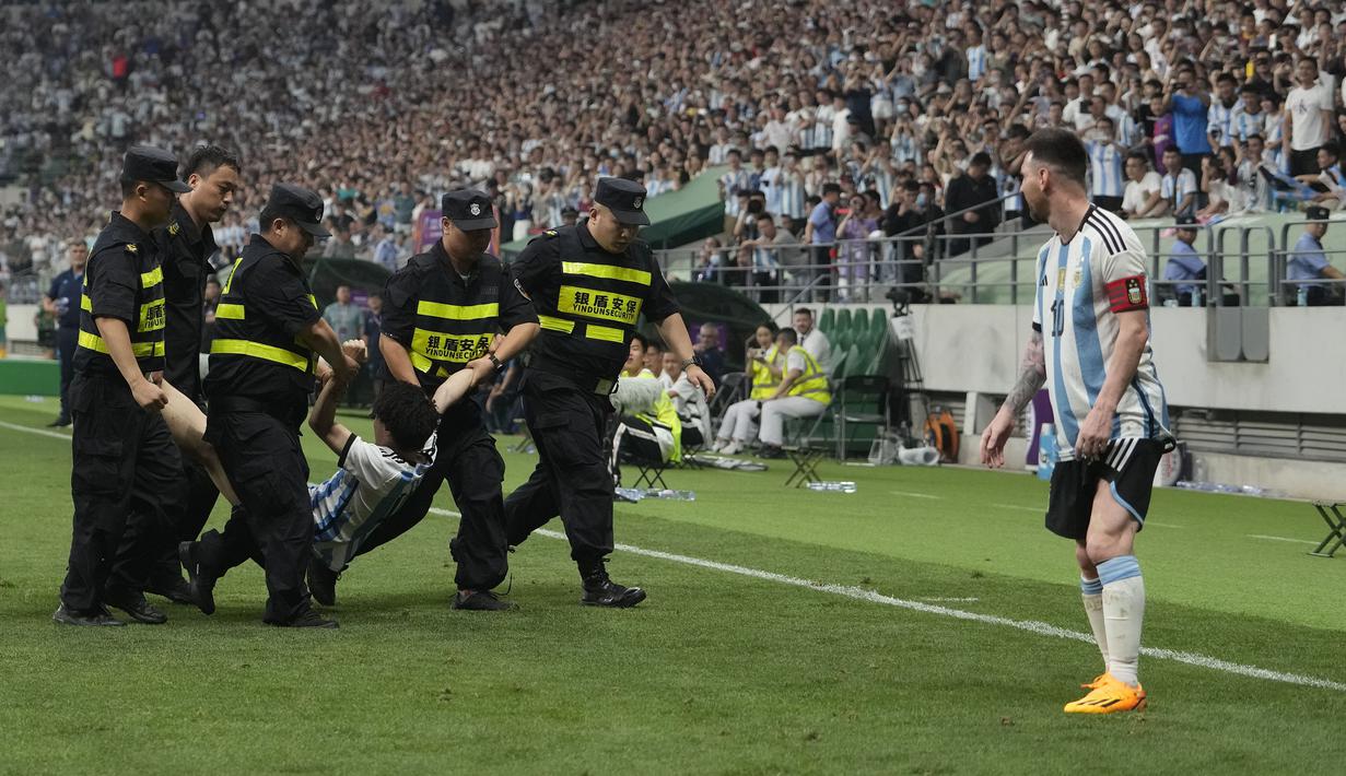 Seorang penyusup lapangan tertangkap petugas pada laga persahabatan antara Argentina melawan Australia di Workers' Stadium, Beijing, Kamis (15/06/2023). (AP Photo/Andy Wong)