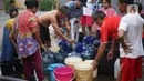 Warga mengisi air bersih ke dalam galon, jeriken, dan ember di kawasan Cipayung, Jakarta Timur, Rabu (20/11/2019). Warga memanfaatkan bantuan air bersih dari Pemprov DKI Jakarta untuk memenuhi kebutuhan sehari-hari. (Liputan6.com/Immanuel Antonius)