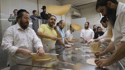 Yahudi Ultra-Ortodoks menyiapkan matzoh khusus di sebuah toko roti di Ashdod, Israel, 11 April 2022. Matzoh adalah roti tradisional tidak beragi yang dibuat untuk Paskah. (AP Photo/Tsafrir Abayov)