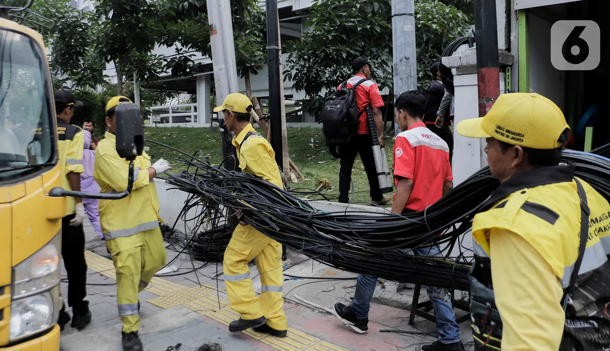 Sampah kabel fiber optik dan tiang-tiang yang telah dipotong ini nantinya akan disimpan di gudang Dinas Bina Marga.   (Liputan6.com/Herman Zakharia)