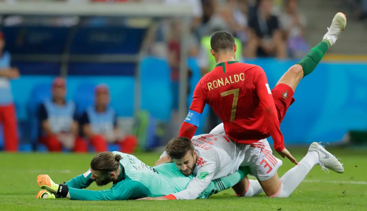 Penyerang Portugal Cristiano Ronaldo bertabrakan dengan pemain Spanyol Gerard Pique dan David De Gea saat bertanding pada grup B Piala Dunia 2018 di Stadion Fisht di Sochi, Rusia (15/6). Portugal dan Spanyol bermain imbang 3-3. (AP Photo/Sergei Grits)
