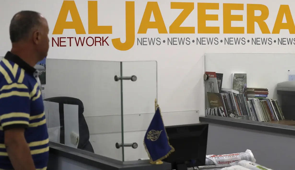 Seorang karyawan berjalan menuju meja kerjanya di kantor berita Al Jazeera, Yerusalem, 31 Juli 2017. Rencana penutupan kantor media di Yerusalem ini juga dikecam Asosiasi Pers Asing yang menganggap Israel mengekang kebebasan pers. (AHMAD GHARABLI/AFP)