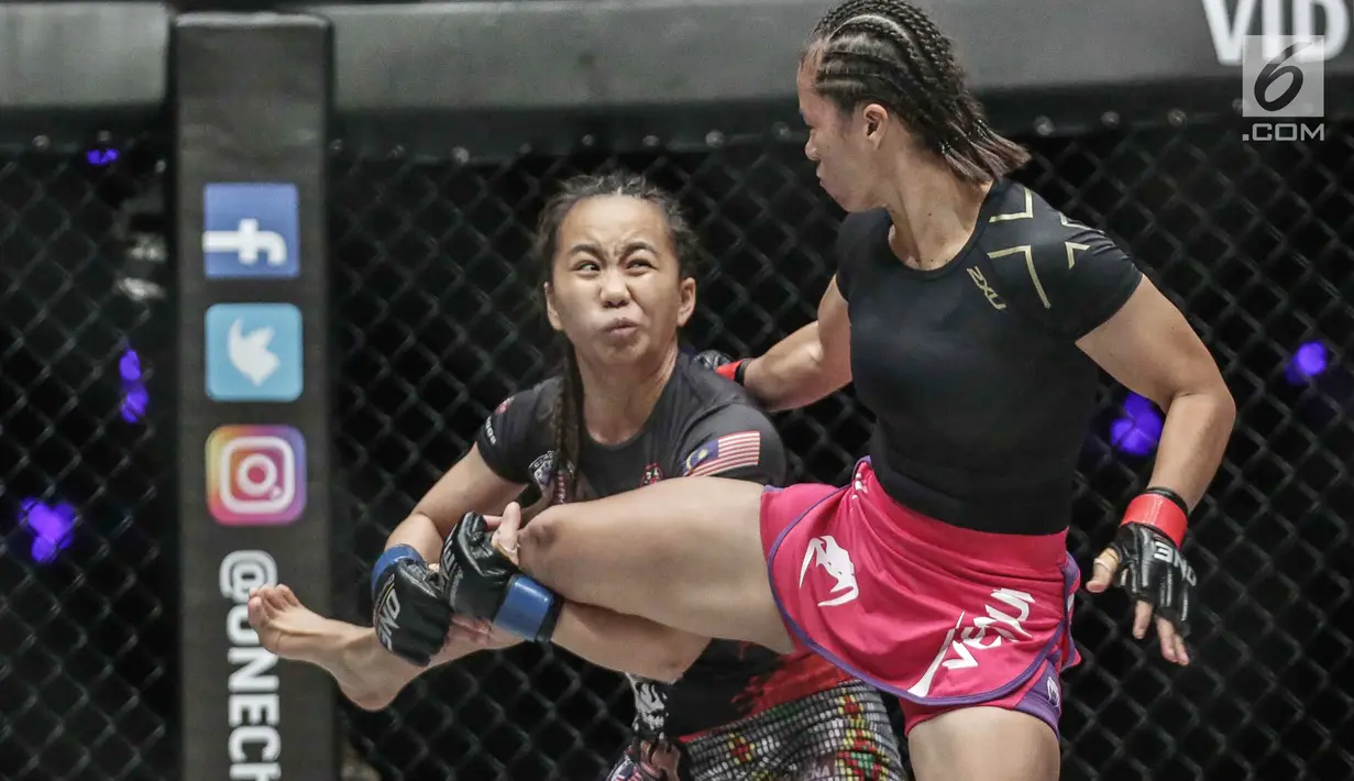 Petarung putri Malaysia, Audreylaura Boniface (kiri) menahan tendangan dari petarung Indonesia, Priscilla Hertati Lumban Gaol (kanan) saat berlaga pada partai pertama One Championship di Jakarta, Sabtu (20/1). (Liputan6.com/Faizal Fanani)