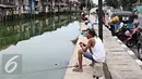 Sejumlah Warga saat memancing ikan di Kali Tanjung Selor, Jakarta, Rabu (20/1). Meskipun keruh dan dipenuhi sampah, namun Kali Tanjung Selor menjadi lokasi favorit bagi warga sekitar untuk memancing dengan biaya murah. (Liputan6.com/Immanuel Antonius)