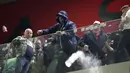Seorang penggemar Polandia melempar botol ke pendukung Albania pada lanjutan Grup I Kualifikasi Piala Dunia 2022 Zona Eropa, di Air Albania Stadium, Rabu (13/10/2021) dini hari WIB. Kemenangan Polandia 1-0 atas Albania diwarnai aksi pelemparan botol oleh suporter. (AP Photo/Franc Zhurda)