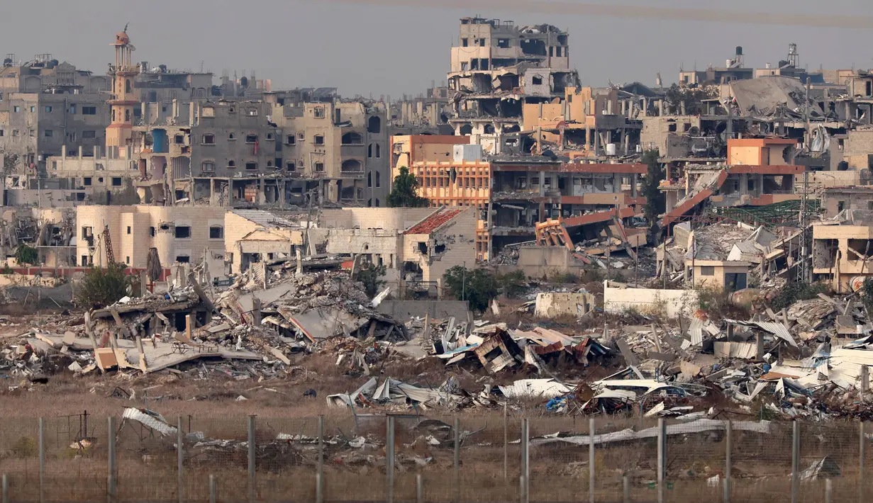 Serangan militer Israel di Gaza memuncak sejak 7 Oktober 2023, hingga kini telah menewaskan lebih dari 45.200 orang yang sebagian besar adalah perempuan dan anak-anak. Tampak dalam foto yang diambil dari perbatasan selatan Israel dengan Jalur Gaza pada 11 Desember 2024, menunjukkan bangunan-bangunan yang hancur di dalam wilayah Palestina. (JACK GUEZ/AFP)