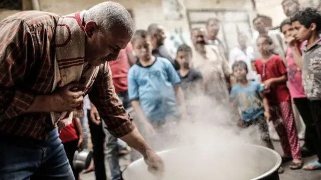 Waleed el-Hattab tampak memasak dalam wadah besar