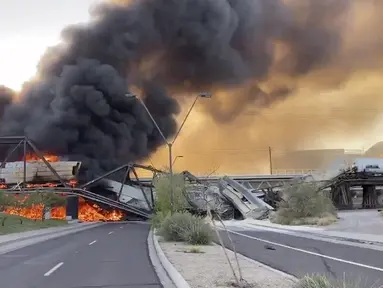 Asap membumbung saat kereta barang tergelincir dan terbakar di jembatan Danau Kota Tempe, Arizona, Amerika Serikat, Rabu (29/7/2020). Tidak ada korban luka dalam kecelakaan yang menurut seorang saksi digambarkan sebagai 'pemandangan neraka' tersebut. (Daniel Coronado via AP)
