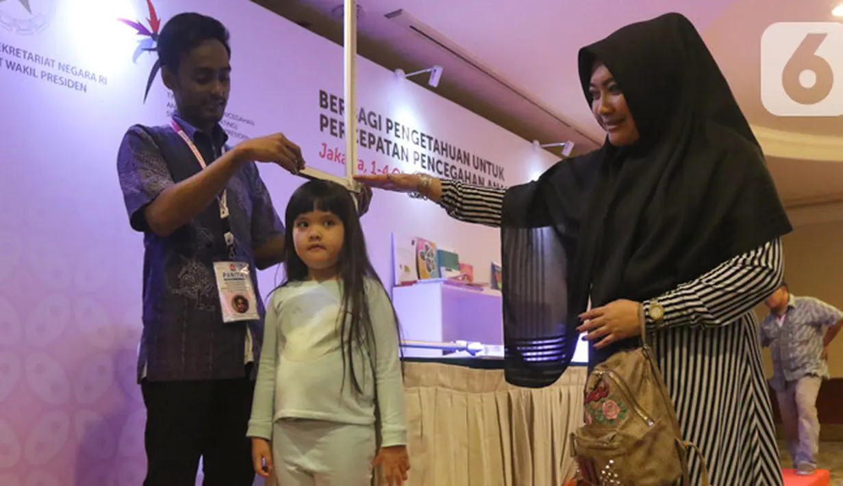 Seorang anak sedang mengukur tinggi badan dalam kampanye perubahan prilaku mendukung percepatan pencegahan stunting di Jakarta, Rabu (2/10/2019). Perwakilan pemda se Indonesia memperoleh bimbingan dari GAIN dalam meningkatkan perilaku gizi. (Liputan6.com/Angga Yuniar)