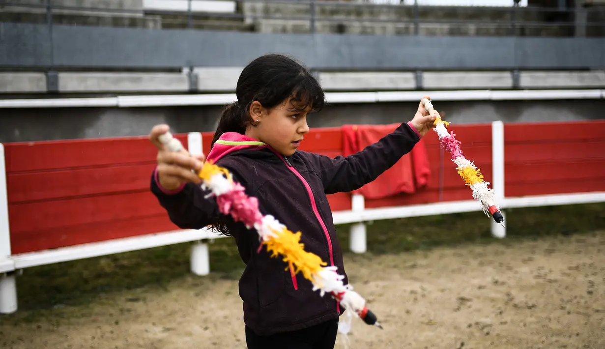 Seorang anak wanita bernama Winona (12) belajar menjadi matador di arena adu banteng Franquevaux di sekolah adu banteng, Prancis selatan (14/4). (AFP Photo/Anne-Christine Poujoulat)