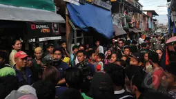 Puluhan warga berkumpul menyaksikan para pewarta melakukan pemberitaan di sekitar lokasi ledakan, jl Jati Bunder, Kebon Kacang, Jakarta Pusat, Rabu (8/4/2015). Akibat dari ledakan ini empat oaring dikabarkan terluka. (Liputan6.com/Johan Tallo)
