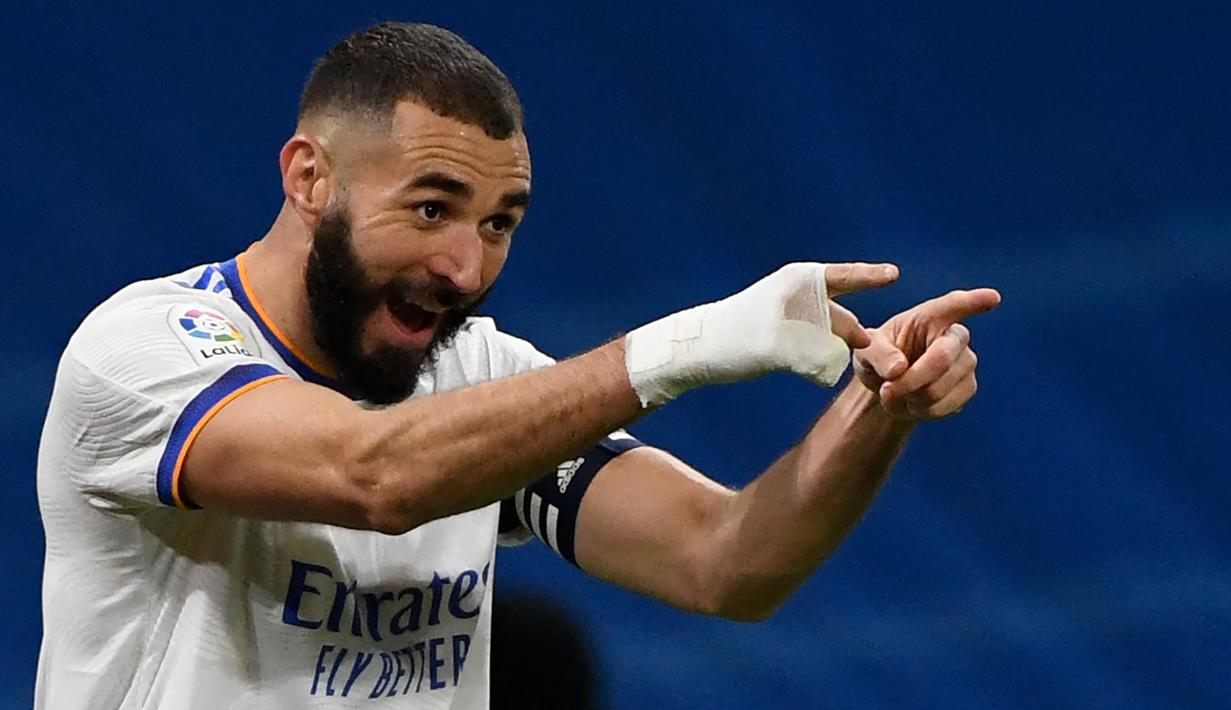 Ada yang menarik dari penampilan peraih Ballon d'Or 2022 Karim Benzema dalam tiga musim terakhir. Ia selalu terlihat mengenakan perban putih yang membalut telapak tangan kanannya saat bertanding di semua ajang kompetisi. Seakan telah menjadi ciri khas hingga kini, namun ternyata ada alasan tersendiri ia mengenakan aksesoris tersebut yang nyatanya jauh dari unsur gaya-gayaan yang akhirnya menjadi inspirasi Adidas merilis film pendek bertajuk Hand of Gold. (AFP/Pierre-Philippe Marcou)